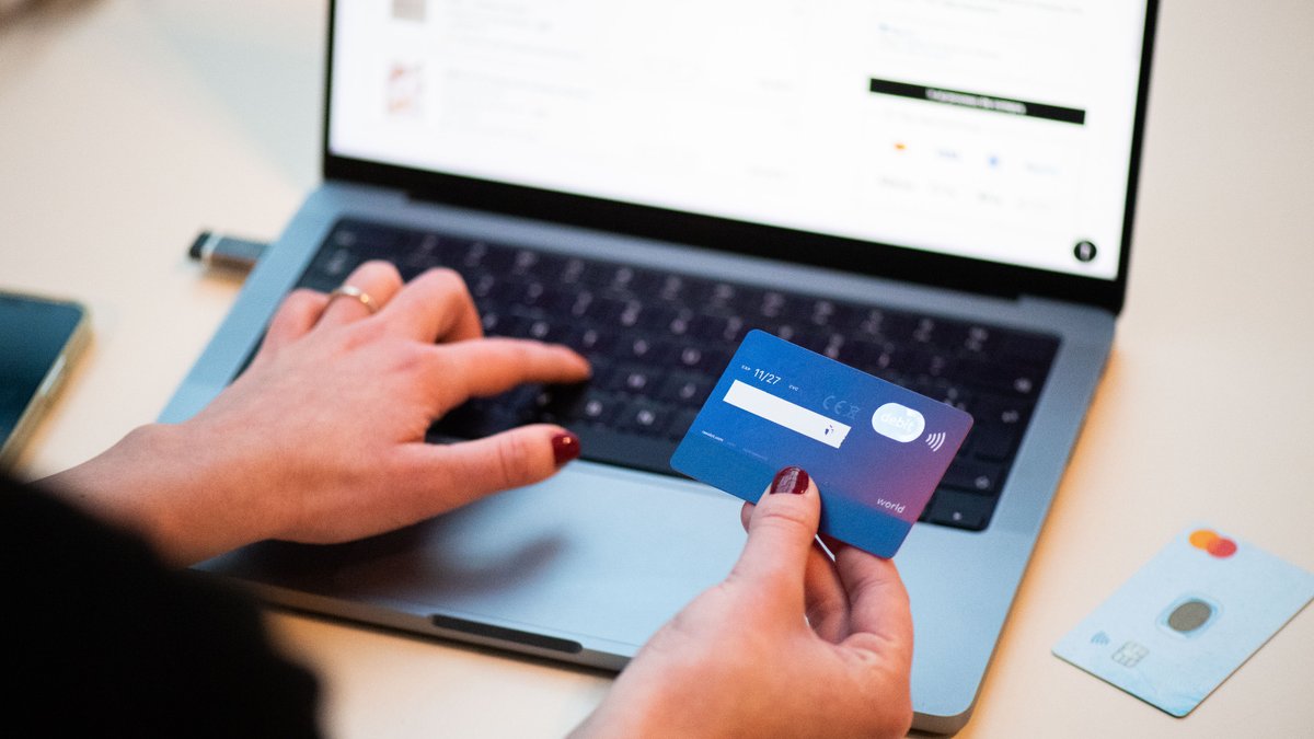 Persona pagando una compra online con tarjeta desde el portátil