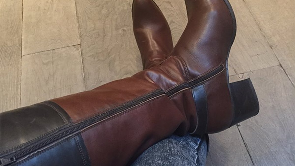 Botas altas de piel en tonos marrón y negro, combinadas con vaqueros